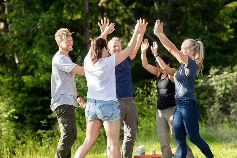 Glade mennesker laver teambuilding-øvelser udendørs